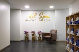 a waiting room with a chair and vases of flowers at Meliá Setúbal in Setúbal