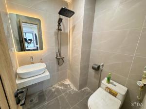 a bathroom with a toilet and a sink and a mirror at Sunshine Housse with Balcony in Centre in Ho Chi Minh City