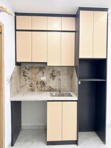 a kitchen with white cabinets and a sink at Sunshine Housse with Balcony in Centre in Ho Chi Minh City