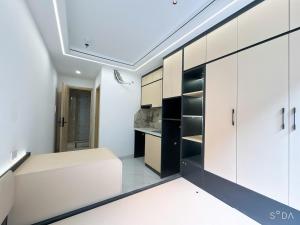 a kitchen with white cabinets and a white bench at Sunshine Housse with Balcony in Centre in Ho Chi Minh City