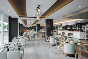 a restaurant with white tables and chairs at INNSiDE by Meliá Yogyakarta in Yogyakarta