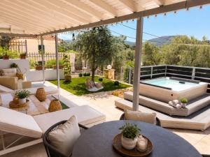 an outdoor patio with a pool and tables and chairs at Blue Topaz cottage Mini pool Spa in Nafplio
