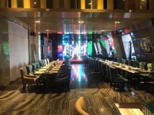 a dining room with tables and chairs and a stage at Harbin Splendent Hotel in Shuangcheng