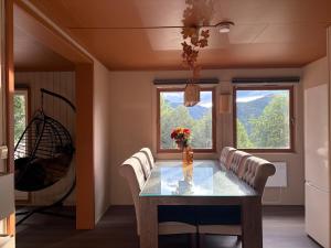 a dining room with a table and chairs and windows at Hytter Brokefjell in Kviteseid