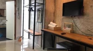 a living room with a table with a television on a wall at palmhouse in Mae Hong Son