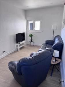 a living room with a blue couch and a tv at Refúgio Templário in Pedreira
