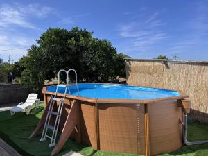 a pool in a backyard with a table and a ladder at Refúgio Templário in Pedreira