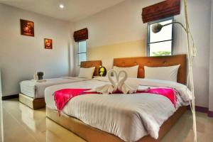 a bedroom with two beds with a bow on them at Baanthanthip in Khon Kaen +103 photos