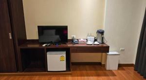a desk with a television and a computer on it at King Hotel in Ban Tha Phae +55 photos