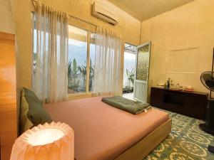 a bedroom with a bed and a large window at Brother House in Nha Trang
