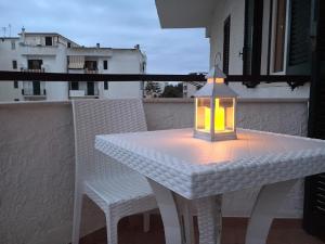 a white table and chairs with a lantern on a balcony at B&B Rossini in Vieste