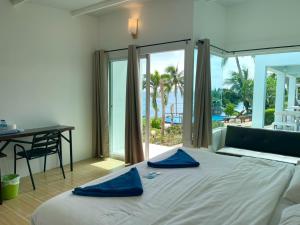 a bedroom with a bed with blue pillows on it at Naiharn On The Rock Resort Phuket in Nai Harn Beach