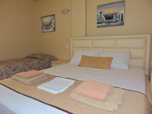 ein Schlafzimmer mit einem Bett, auf dem zwei Handtücher liegen in der Unterkunft Avanda Rooms in Dhërmi