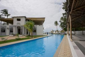a swimming pool in front of a building at Sea Side Resort in Paje