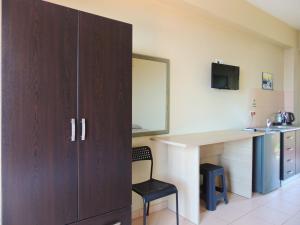ein Zimmer mit einem Schreibtisch, einem Stuhl und einem Schrank in der Unterkunft Avanda Rooms in Dhërmi