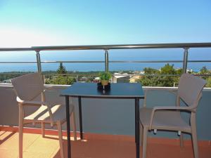 ein blauer Tisch und zwei Stühle auf einem Balkon in der Unterkunft Avanda Rooms in Dhërmi