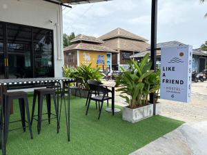 a sign that says like a friend next to a table and chairs at Like A Friend Hostel in Thong Sala