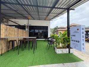 a patio with a table and chairs on green grass at Like A Friend Hostel in Thong Sala