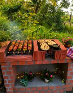 a grill with hot dogs and other foods on it at Apart Cabaña KTIK in San Bernardo del Viento