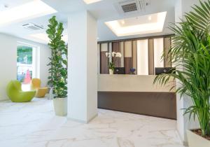 an office lobby with plants and a reception desk at Meliá Venezia Lido in Venice-Lido