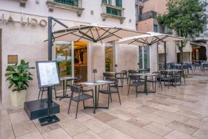 a group of tables and umbrellas in front of a building at Meliá Venezia Lido in Venice-Lido