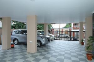 two cars parked in a parking lot at Hotel Shreyash in Solapur