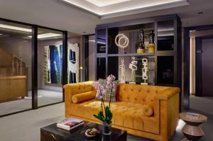 a living room with a yellow couch and a table at MiM Andorra member of Meliá Collection in Escaldes-Engordany
