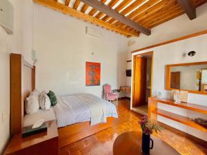 a bedroom with a bed and a table in a room at El Serafin Hotel Boutique in Querétaro