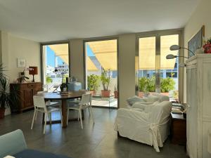 a living room with a table and a couch and chairs at La mia terrazza sul mare - Mared'aMare in Bari