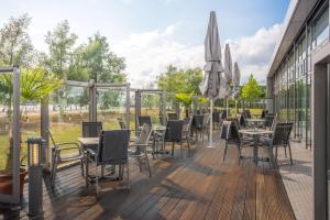 a deck with tables and chairs and an umbrella at INNSiDE by Meliá Bremen in Bremen