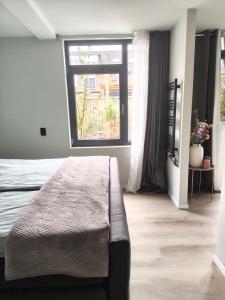 a bedroom with a bed and a large window at Boterbloem Bed en Brood in Hardenberg