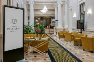 a sign in a lobby with a table and chairs at Hotel President Budapest, Affiliated by Meliá in Budapest