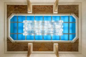 a blue window with a white curtain at Hotel President Budapest, Affiliated by Meliá in Budapest