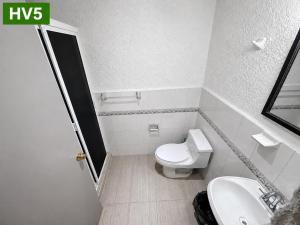 a small bathroom with a toilet and a sink at VIRREYES418 extended apartments in Los Valdeses