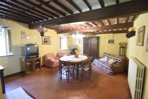 uma sala de estar com uma mesa e uma televisão em Casale Irene em Pescaglia