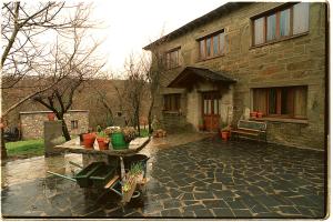 a stone house with a table in front of it at Hotel Rural El Rincón de Trefacio in Trefacio