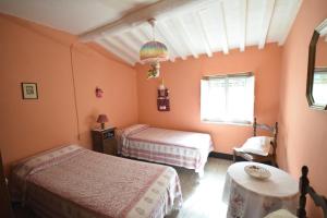 een slaapkamer met 2 bedden en een tafel bij Casale Irene in Pescaglia