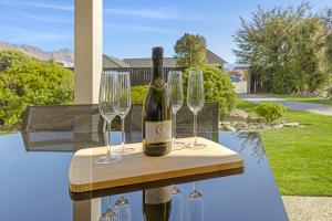 a bottle of wine and two wine glasses on a table at Spacious Alpine View Resort in Wanaka