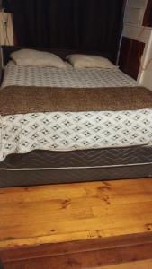 a bed sitting on top of a wooden floor at Hospedaje Alondra in Osorno +6 photos