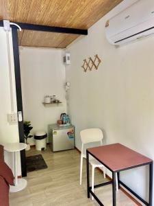 a living room with a table and a kitchen at Chalok Garden bungalow in Ko Tao