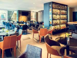 a restaurant with tables and chairs and a bar at Mercure Uberlândia Plaza Shopping in Uberlândia
