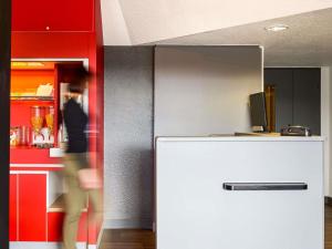 a kitchen with a white refrigerator and red cabinets at hotelF1 Beauvais in Beauvais