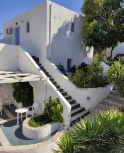 a staircase leading up to a white building with plants at Porto Sikinos Hotel in Alopronia
