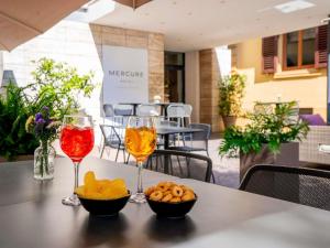 two glasses of wine and snacks on a table at Mercure Firenze Centro in Florence