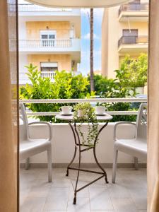 a table and two chairs on a balcony at Home Volos in Volos