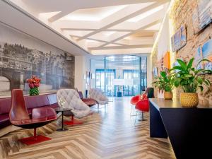 a lobby with red chairs and a waiting room at Mercure Firenze Centro in Florence