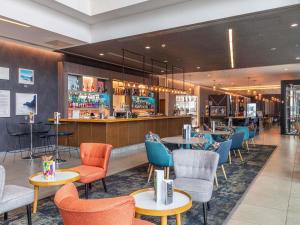 a restaurant with tables and chairs and a bar at Pullman Liverpool in Liverpool