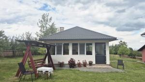 a small house with a porch and a swing at Cabana Codrii Apusenilor - Matis in Râșca