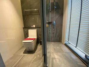 a bathroom with a toilet and a glass shower at Stunning Sea View Condo -Next To Beach in Pattaya South