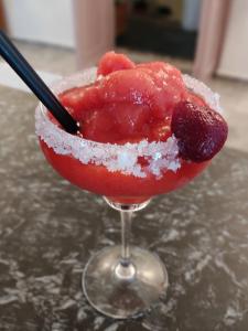 a red drink with a black straw in a martini glass at Porto Sikinos Hotel in Alopronia